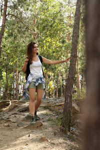 夏天的时候带着背包的年轻女子在森林里。野营季节
