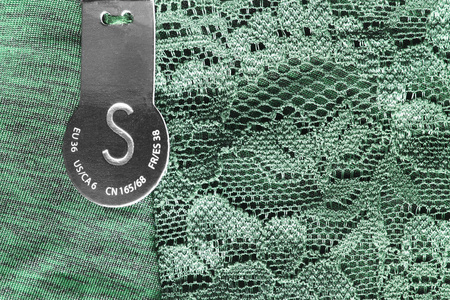 Xs 尺寸纺织服装标签特写在棕棉背景上