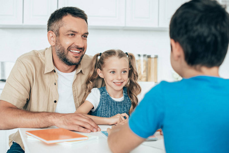 微笑的父亲和孩子在家一起做家庭作业