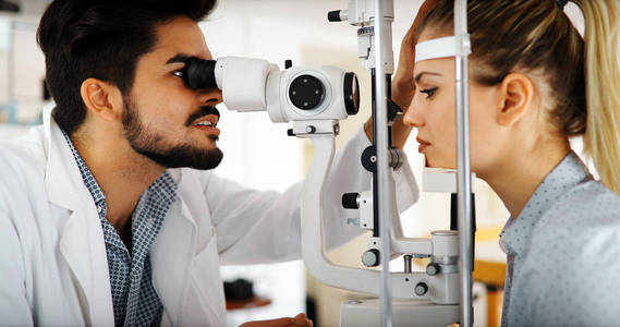 验光师检查病人的视力和暗示视觉矫正治疗