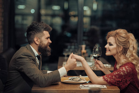 美丽 年轻夫妇带着眼镜的红酒在豪华餐厅