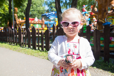 小女孩在乐趣公园与传送带在夏天天