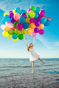 多色的彩虹气球与年轻时尚美女