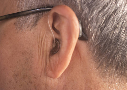 戴现代数字高科技助听器的聋人老年公民