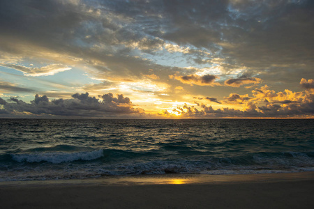 美丽的日落在海滩上。多云的天气在水面上反射了很多东西