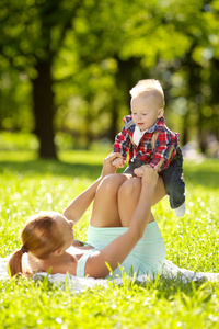 可爱的小宝宝和妈妈在草地上在公园。甜 bab
