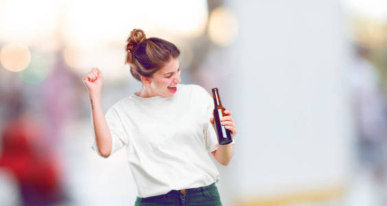 年轻美丽的女孩高兴与啤酒瓶图片