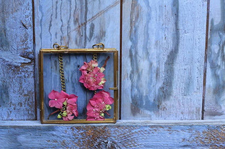 复古风格的粉红色绣球花的形象, 在一个黄铜玻璃框架上的蓝色彩绘质朴木门, 不寻常的婚礼装饰