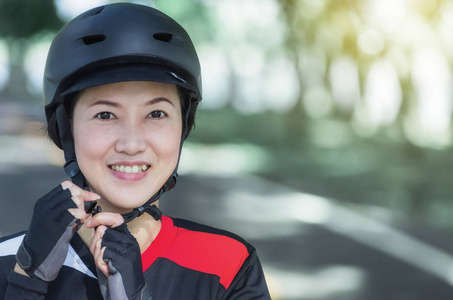 自行车头盔亚洲妇女佩戴头盔准备骑车者