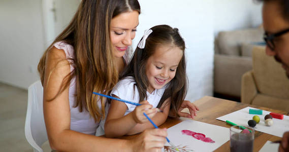 绘画与她的母亲一起在家里的小女孩