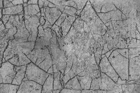 一个旧的混凝土彩绘墙上覆盖着一个大而裂缝的网络作为背景。旧石墙纹理表面的裂纹网格