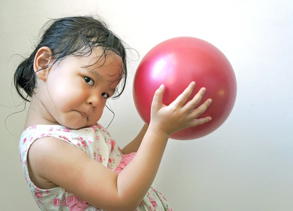 小女孩拿着红球