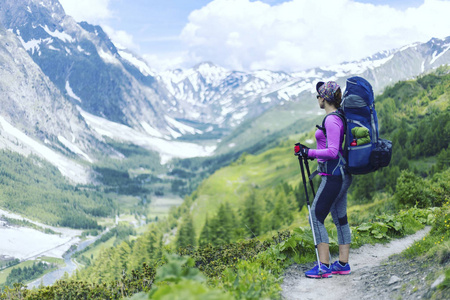 运动在勃朗峰附近。那个女孩带着背包走在小路上。