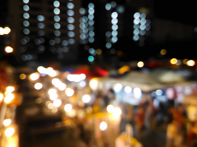 模糊高视角的人在夜间市场上漫步, 色彩艳丽, 散景背景明亮。