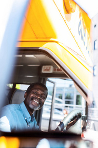 快乐成熟的非洲裔美国人公共汽车司机看摄像头