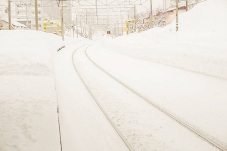 冬季冰雪覆盖城市的景观景观与特写金属长铁轨在暴风雪背景下的全白雾