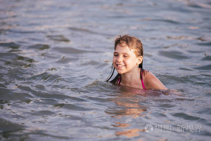 炎热的夏天快乐的小女孩在水中游泳