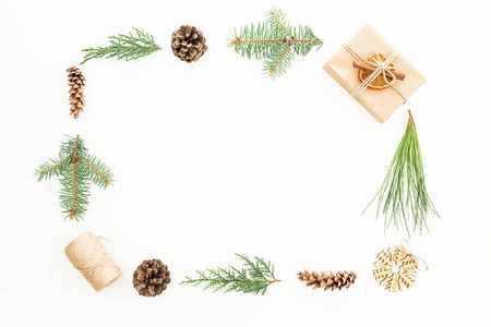 创造性的圣诞框架与礼物, 冬天树和松果的分支在白色背景。平躺着。顶视图