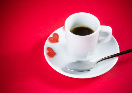 装饰红心附近杯咖啡上红色餐桌边，概念的情人节