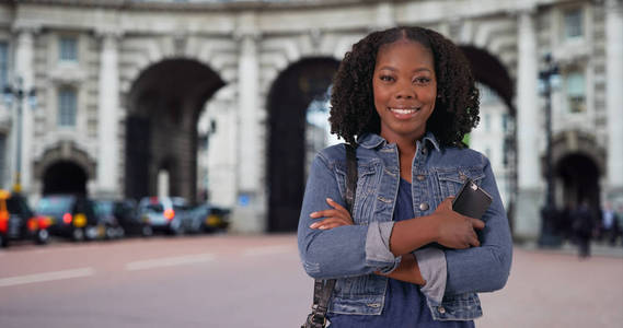 在伦敦旅行的黑人女性在地标前摆姿势, 对着镜头微笑