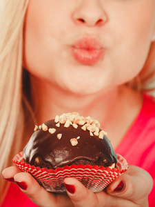 饮食 糖果 食品的概念。可爱的金发美女，要吃美味的巧克力蛋糕，空气吻向她的甜点
