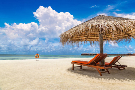 马尔代夫2018年6月24日 夏季日在马尔代夫热带海滩上的木制日光浴和雨伞