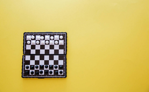 小口袋棋子, 塑料棋子放在黄色背景顶视图上的棋盘上