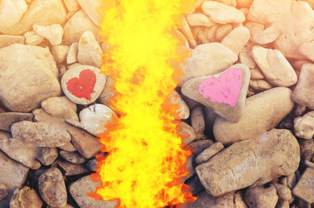 在一块石头上涂上口红的粉红色的心脏切割火跳水。爱的终结和两个人分手和离婚的象征