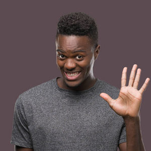 年轻的非洲裔美国人穿着灰色 t恤显示和指向五的手指, 而微笑着自信和快乐