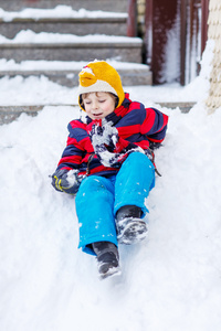 孩子玩骑雪，outd 颜色鲜艳的衣服的男孩