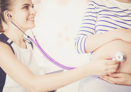 女医生与听诊器在医院与孕妇交谈