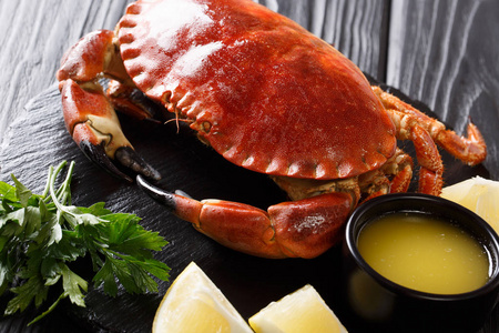 美食海鲜 在一张黑色桌子上的石板板上, 用酱油柠檬和欧芹煮全褐色蟹。horizonta