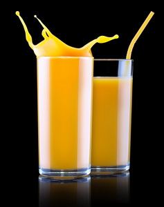 新鲜的橙汁在玻璃时溅起水花图片