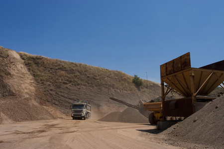 卡车和推土机在石矿场工作