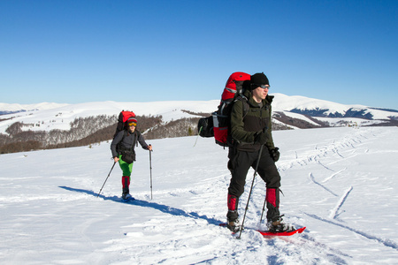 在山里徒步旅行带着背包和帐篷雪的冬天