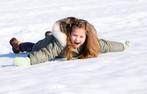 快乐的孩子躺在雪地里