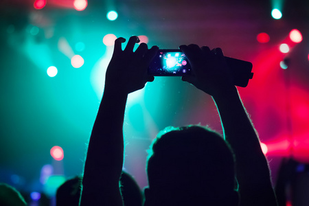 在音乐会拍摄视频或照片的人