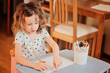 用彩色铅笔在家里画的学龄前儿童女孩