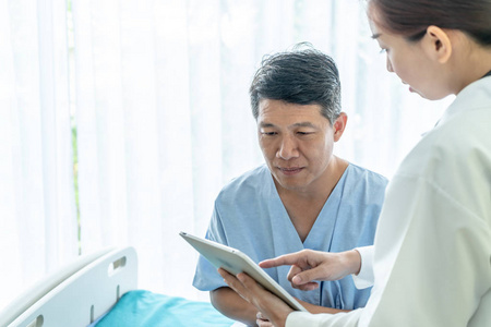亚洲高级病人在病床上与女性医生选择性聚焦点讨论