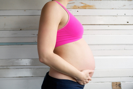 一个怀孕的女人牵着胃的侧面视图肖像