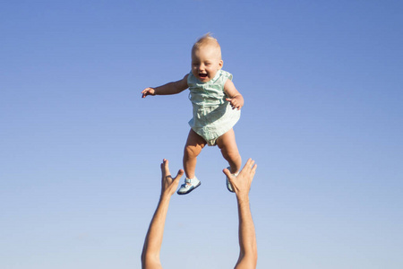 男人把婴儿扔到蓝天上。概念游戏与孩子, 幸福的家庭