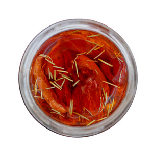 红色自制烤箱干西红柿, 在一个玻璃罐子里塞满橄榄油, 顶部视图, 特写, 在白色背景下被隔离