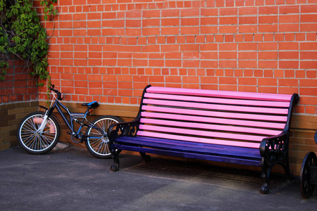 粉红色的老式长凳和自行车后欧洲风格。砖墙背景, 对象