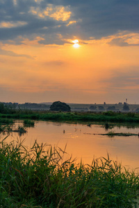 夏日傍晚, 小河流上的橙色日落。河风景