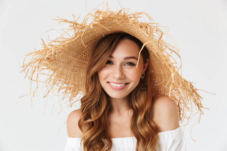 魅力迷人的女人的肖像特写20s 戴着大草帽在相机上摆出可爱的笑容, 在白色背景下被隔离