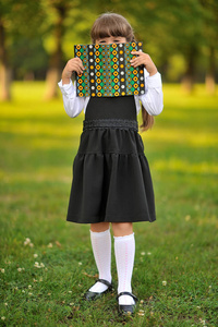 漂亮的女学生在制服与一本书