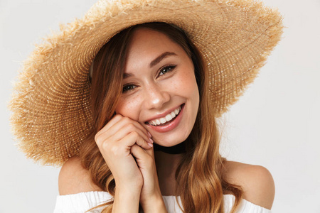 照片的迷人的女人20s 戴着大草帽看着相机与快乐的笑容孤立的白色背景