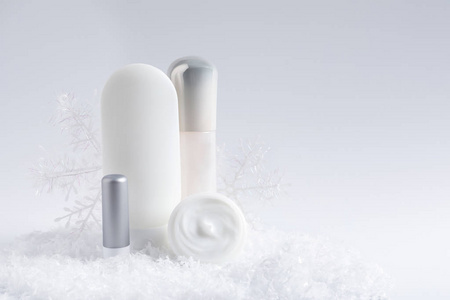 一套化妆品和装饰雪的白色背景, 空间为文字。冬季护理