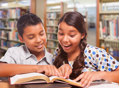 西班牙裔男孩和女孩在图书馆一起学习乐趣