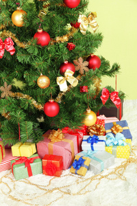 装饰圣诞树用绿墙背景上的礼物